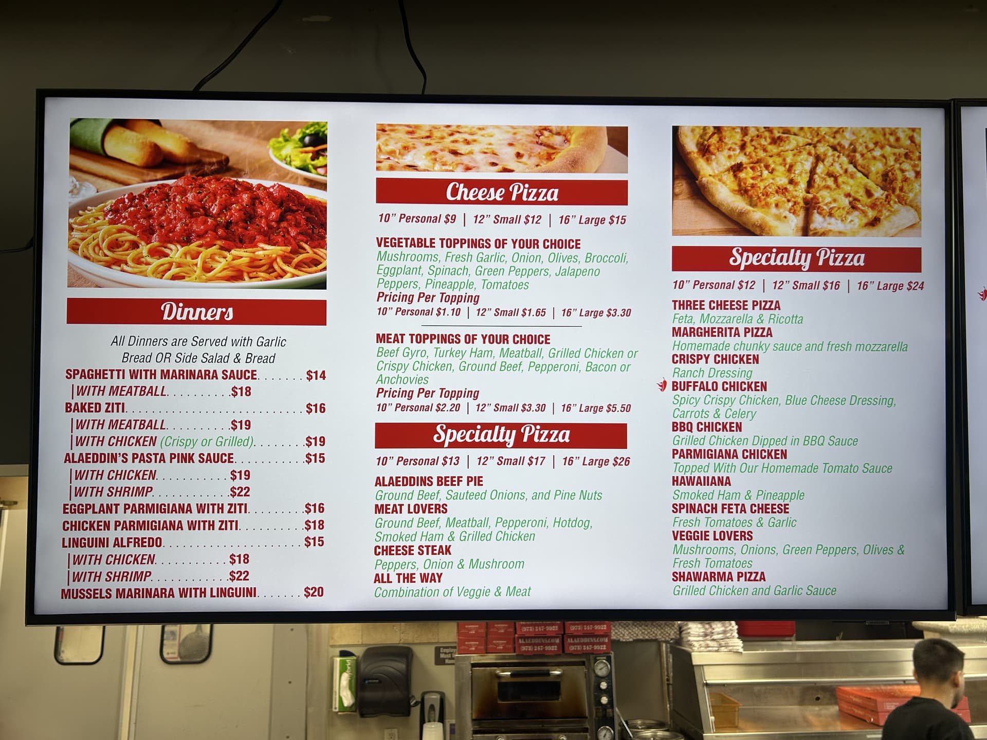 Digital menu screen above the counter at Alaeddin's Pizza in Clifton, NJ